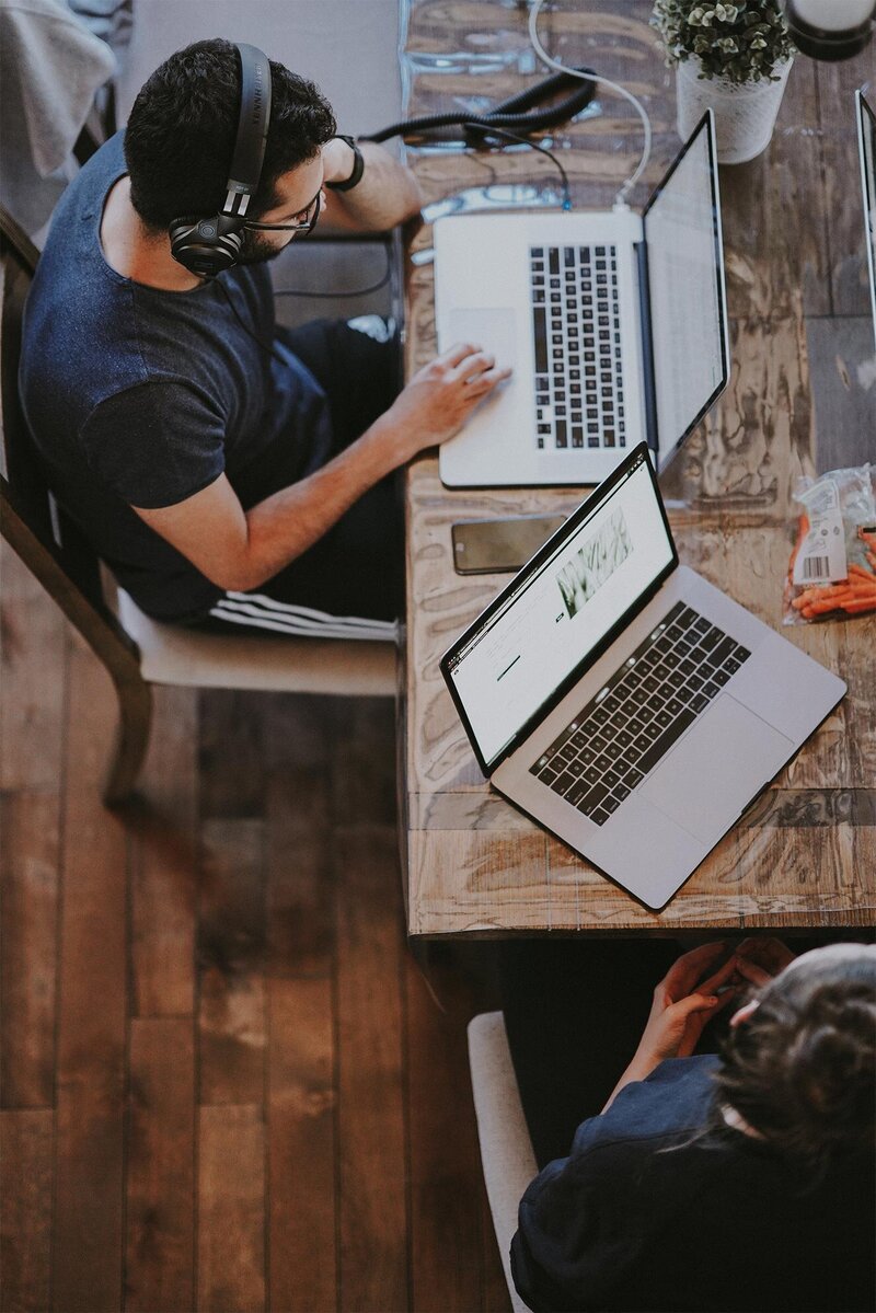 People working at table on laptops