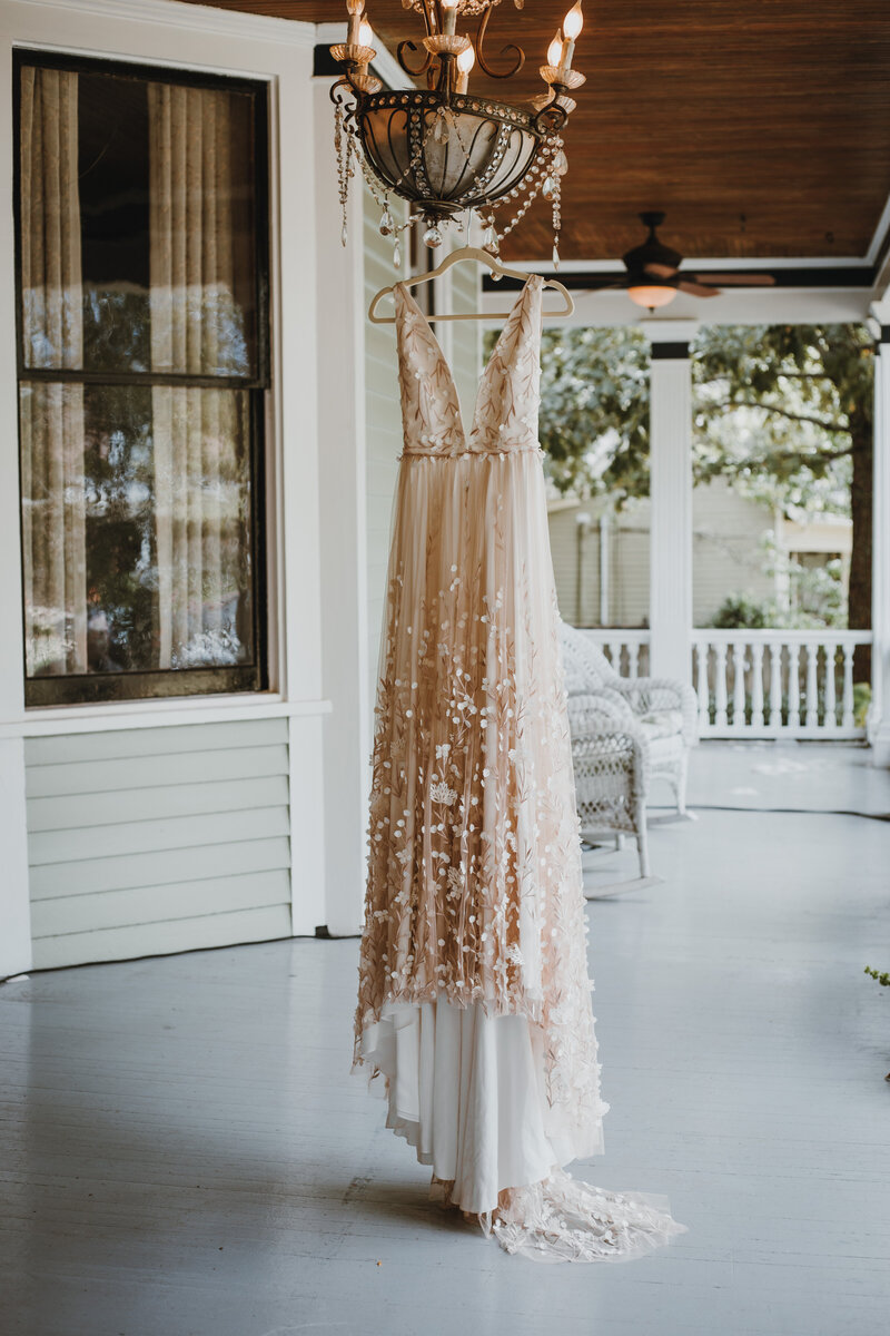 wedding dress hanging outside on a covered porch