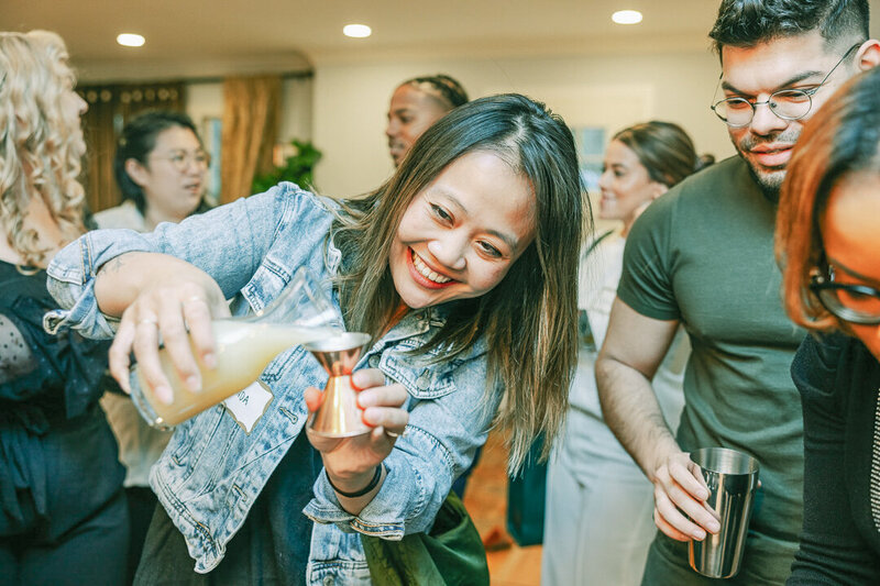 A bartender muddling fresh fruit in a glass in a mixology class