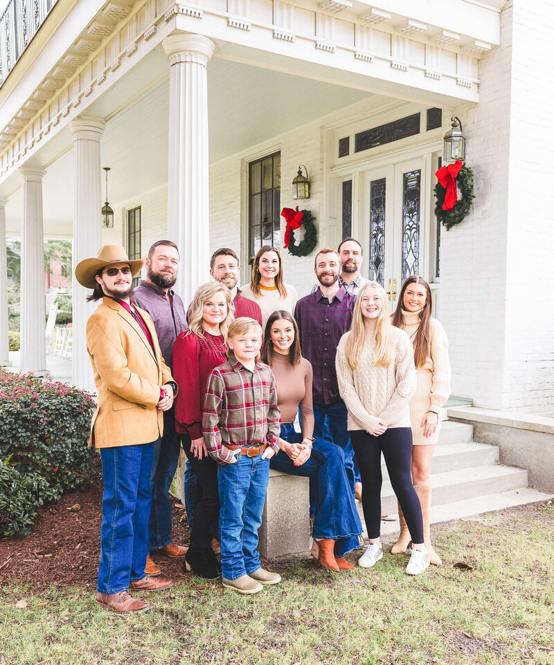 Extended family dressed up for holiday family photos posing on porch in fayetteville nc