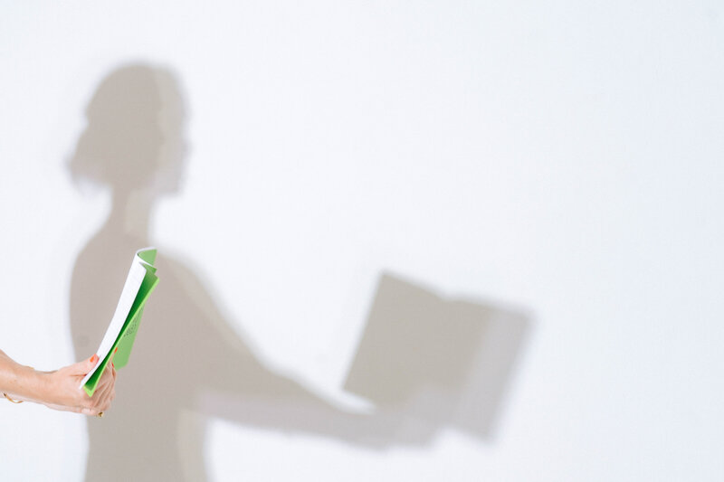 shadow of woman holding a book open