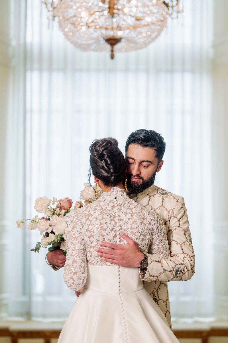 sikh couple holding hands in white and red attire while smiling