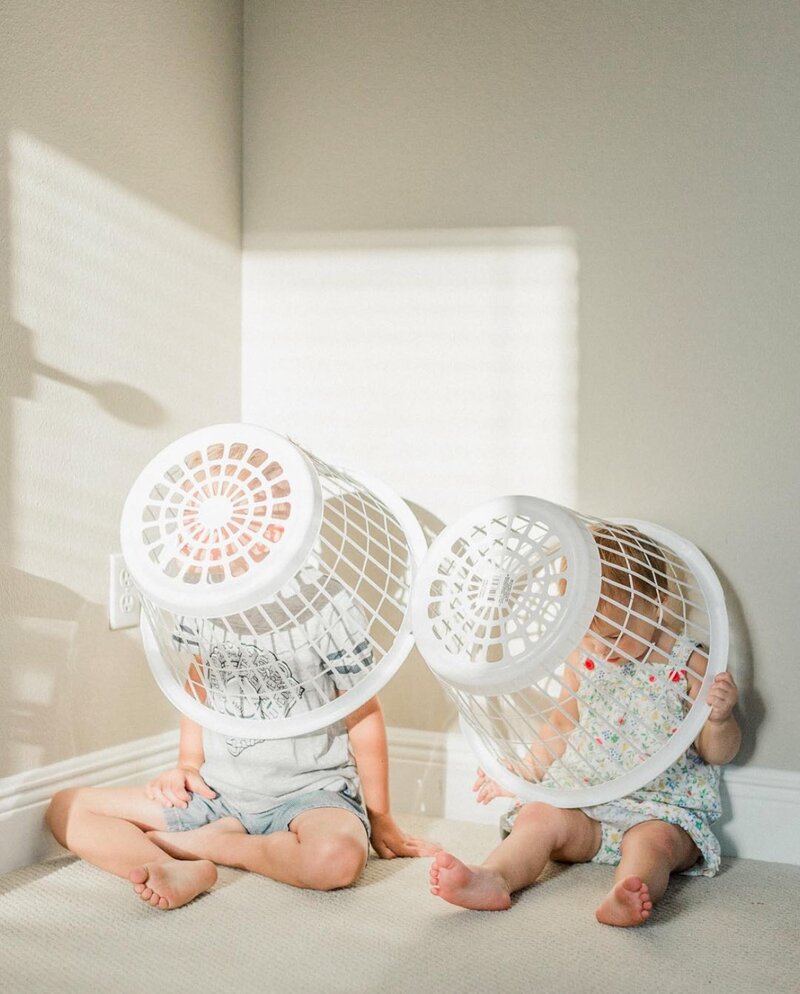 toddlers playing with laundry baskets from  beginner photography course for moms