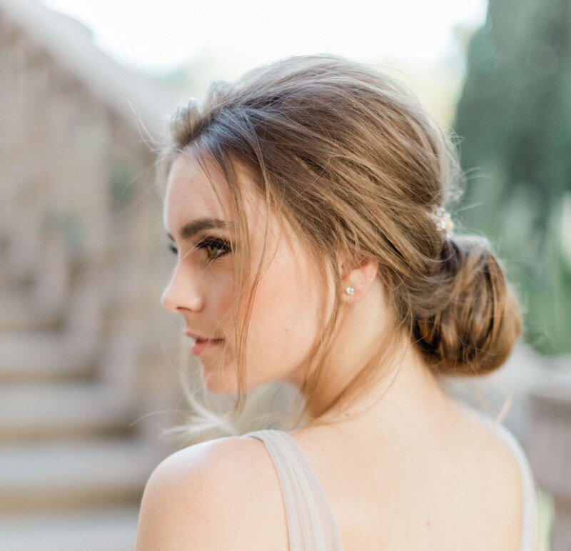 Kohnur bride profile with soft natural makeup and a textured low bun updo at Villa Del Sol D’Oro Sierra Madre California.