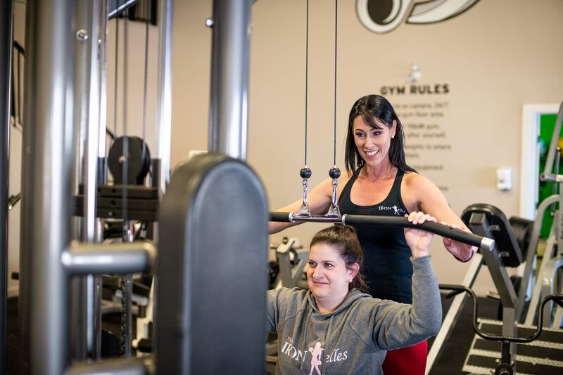 Personal Trainer assisting client with back exercise