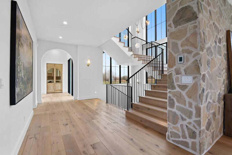 Grand staircase design with custom statement lighting in The Chateau Moderne project by Boise Custom Home builder Jeff Thompson of Thompson Homes