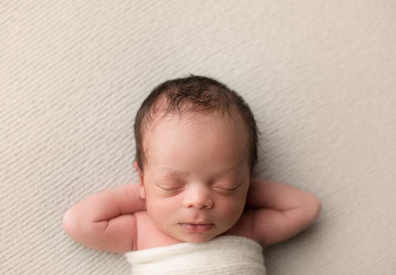 Newborn baby boy in relaxed pose in studio captured by newborn photographer Candice Berman Photography