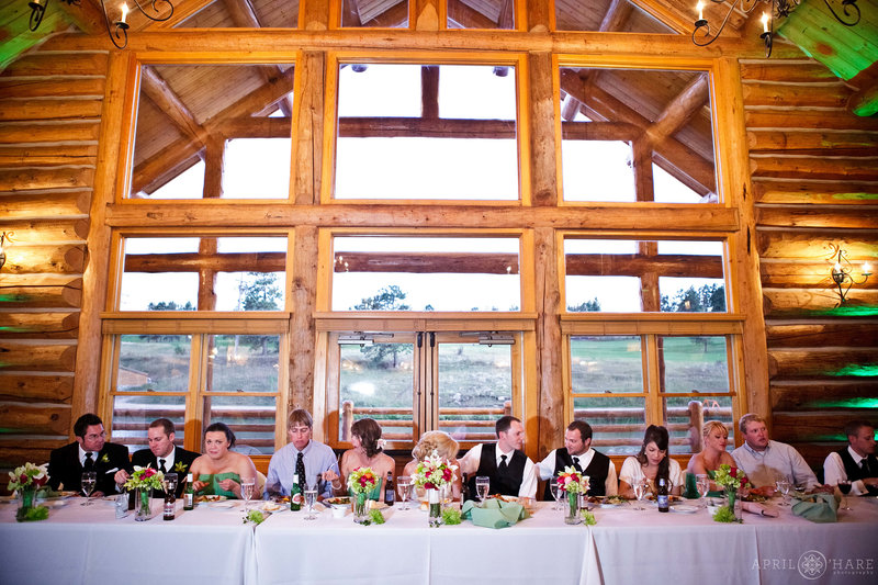 Head table set up in front of windows and doors on the south side of Evergreen Lake House