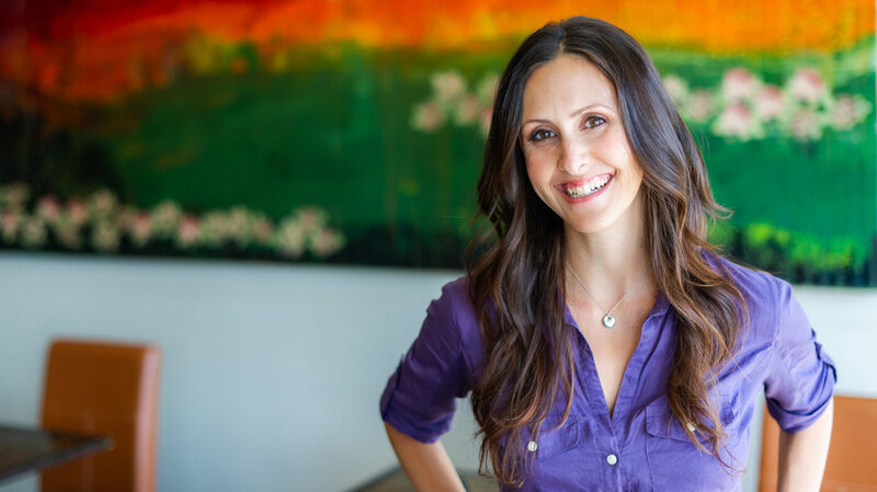 Headshot of Chef Jenny Ross, owner of 118 Degrees restaurant in Costa Mesa, CA smiling and wearing a purple shirt.