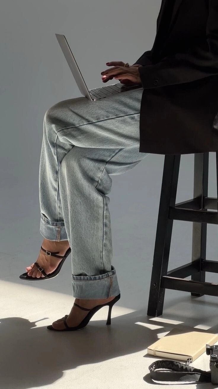 Woman working on a laptop in heels and jeans, symbolizing the freedom to access The Clair Academy’s digital downloads, ebooks, workbooks, and guides from anywhere.