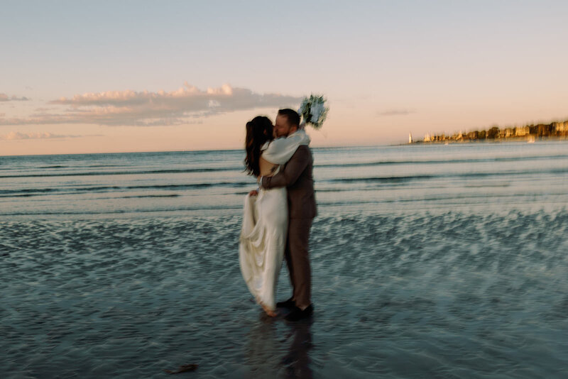 Bride and groom blurry candid photo kising at their elopement on the beach in Massachusetts
