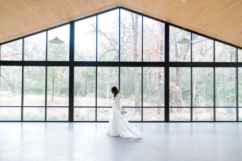 Bride standing in front of a large wall made of windows