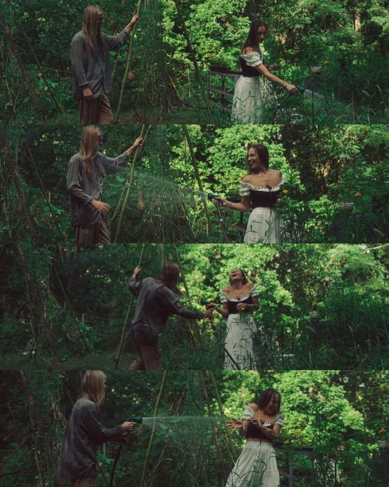 couple playing in the garden with the water hose 
