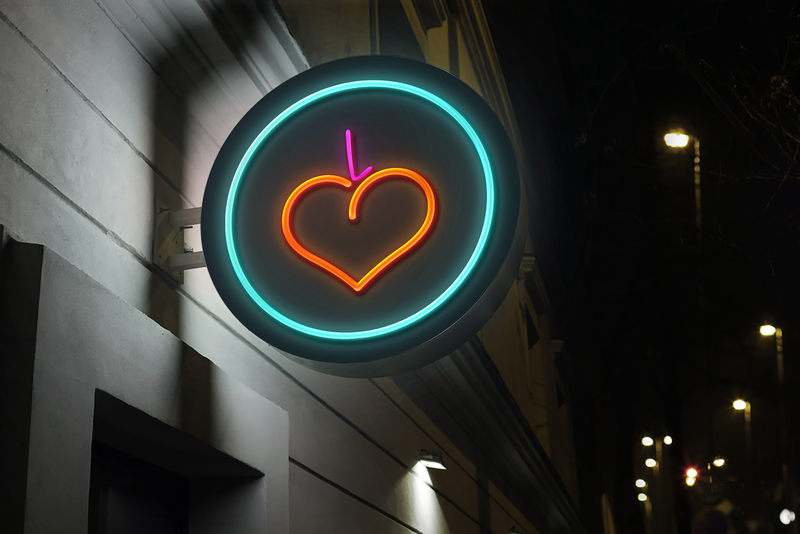 Exterior blade at night with lit neon sign featuring Lovey peach symbol
