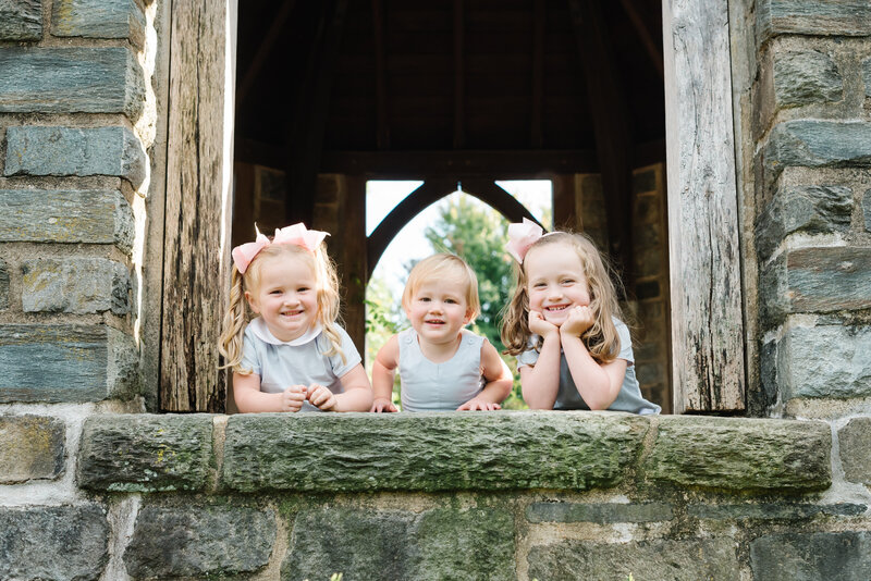 Three children smiling and leaning on a stone wall - Northern Virginia family photographer