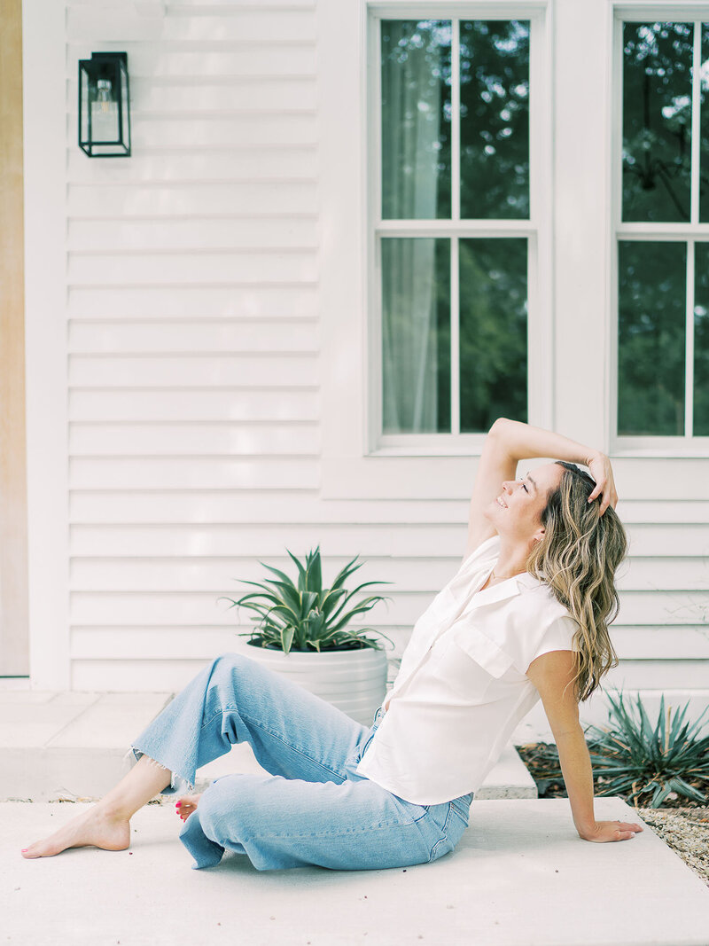 Teressa Jane, San Antonio Newborn Photographer sits on her porch with her head turned up to the sun