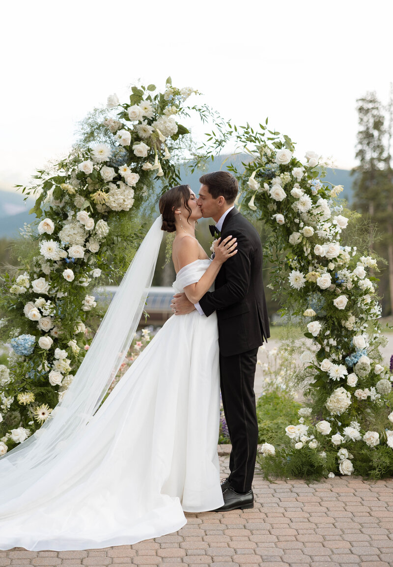 bride and groom kissing in front of giant windows