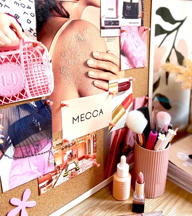 Close up of Lady Elk Studio's desk showing a  cork moodboard in pink theme
