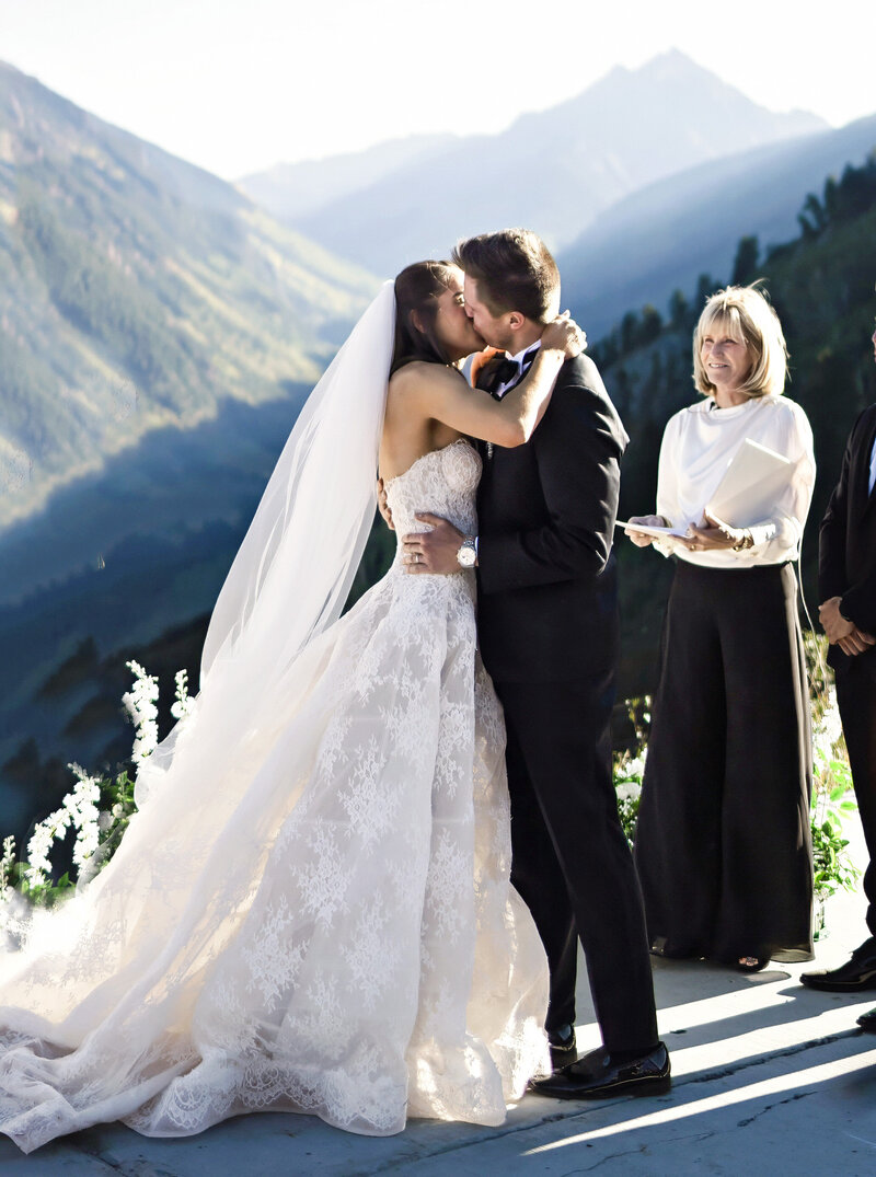 A beautiful bride holds her bouquet and has a cowboy hat on for her aspen, colorado wedding,