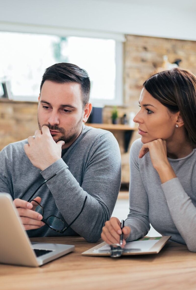 Couple sitting in front of a laptop engaging in a structured online program for betrayal trauma recovery. Online affair recovery programs can help you heal from betrayal trauma. Schedule a free consultation today.