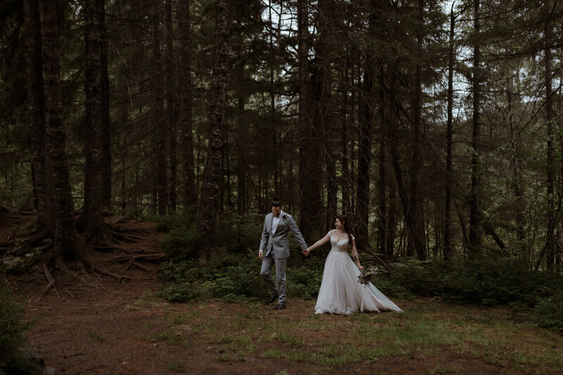 bride and groom walking in forrest