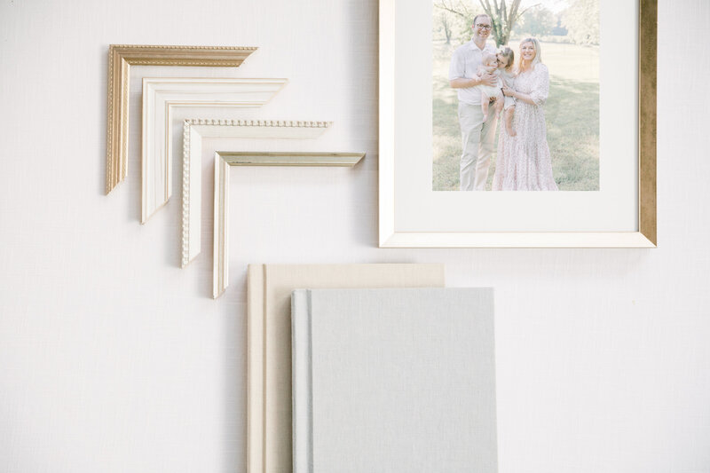 Flat lay of open albums with family portraits and neutral tones