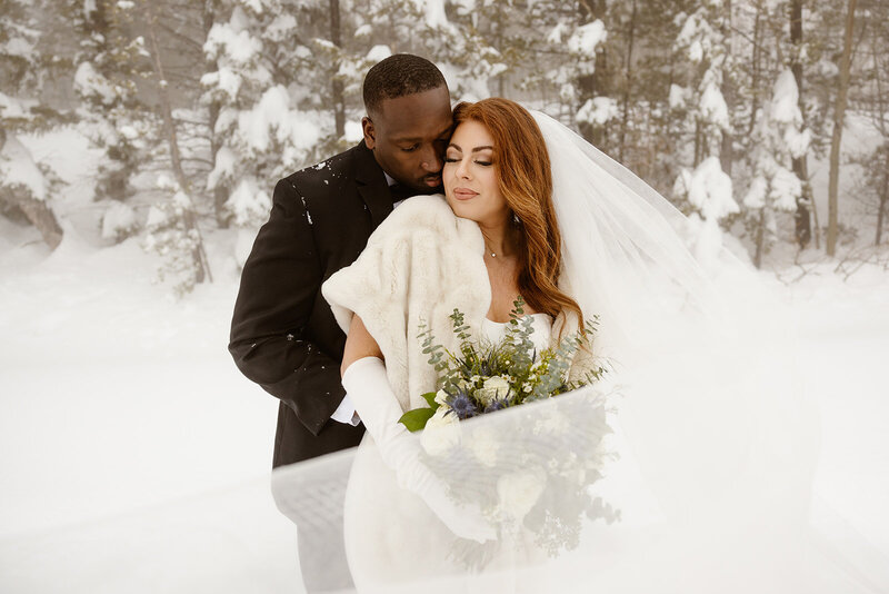 A biracial couple shares an embrace after their wedding ceremony in Lily Lake, Rocky Mountain National Park, Colorado. 