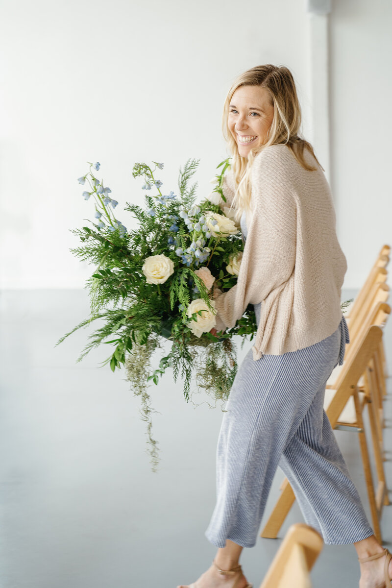 Shelby moving flowers created by Wild Alpine Floral to wedding ceremony at Magnolia Cottage wedding venue in Emmett, Idaho captured by Bramble and Vine Photography