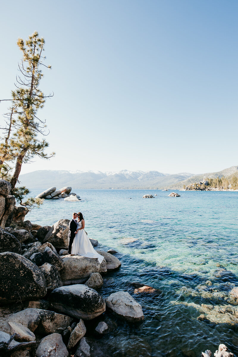Bride and groom sharing a playful, romantic moment in a golden meadow at Yosemite National Park, with towering granite cliffs in the background