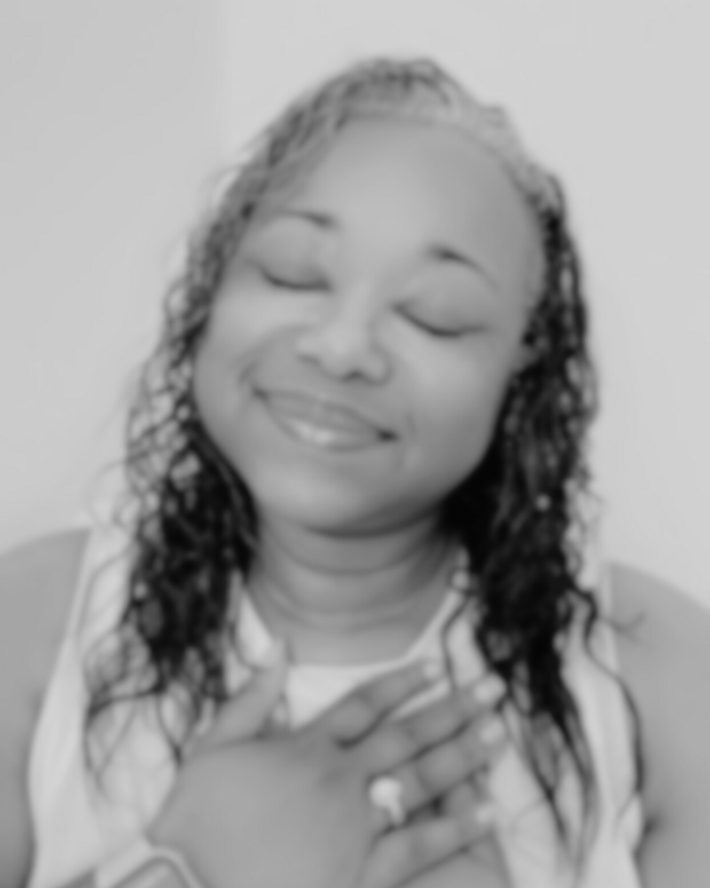 Letitia Hopkins with eyes closed and hand over her heart, embodying self-love, trust, and Main Character Energy as a life, love, and relationship coach guiding women to heal, grow, and create aligned love and relationships.