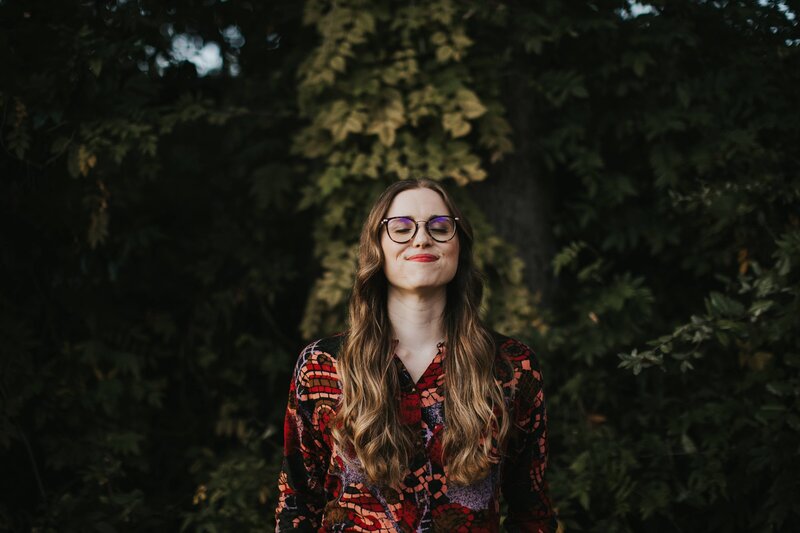 Photograph of staci (a white woman with long hair) outside in the fall
