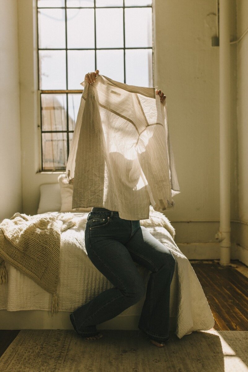 Light shining through a shirt being held by a woman