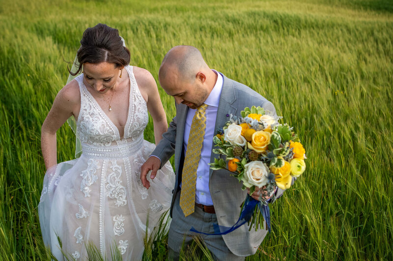 bride and groom standing in barley field