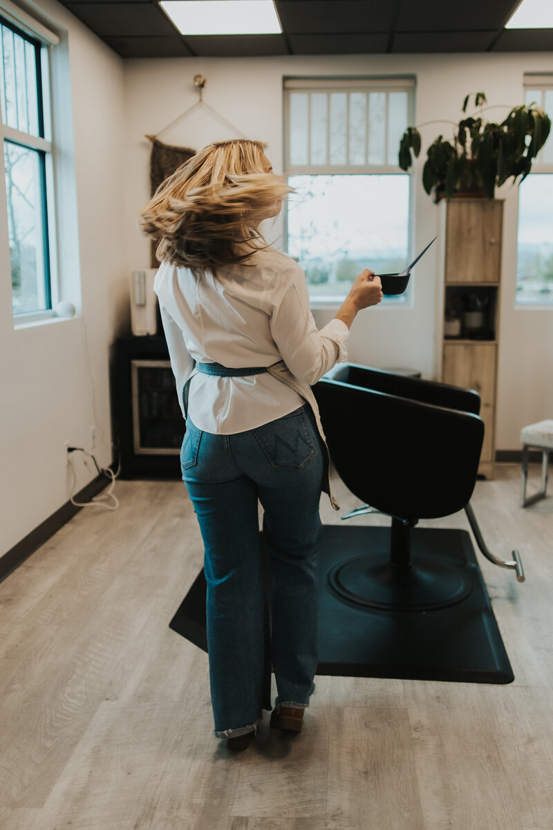 Casper, WY artist flipping hair while blending color in studio 