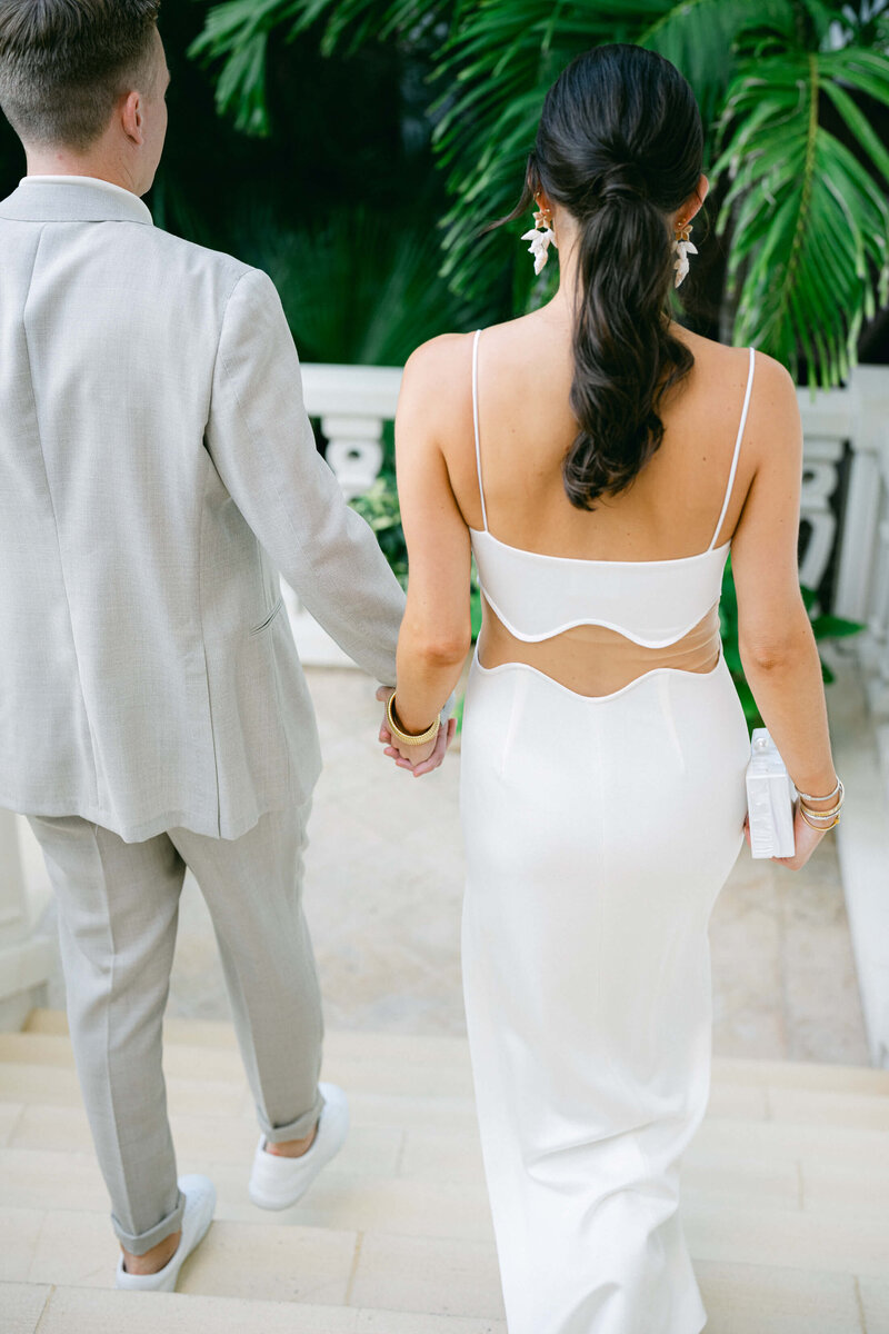 Bride and groom holding hands walking to their wedding reception in Nassau, Bahamas