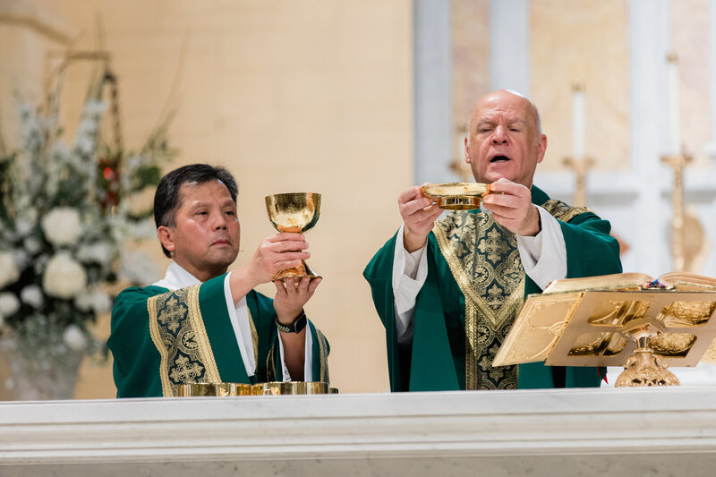 Two men performing a religious ceremony in a church.