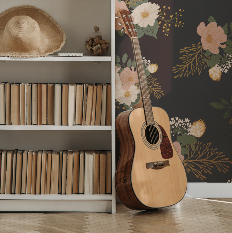 highly textured hand drawn floral groupings pattern in warm rich colors of salmon, soft pinks, cozy yellows, and relaxing browns are featured on wallpaper in a bedroom with a guitar - pattern is available for licensing