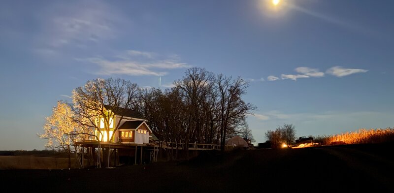 An enchanting view of TreeHouse Heaven's treetop wedding venue at sunset, showcasing its elevated decks and natural surroundings.