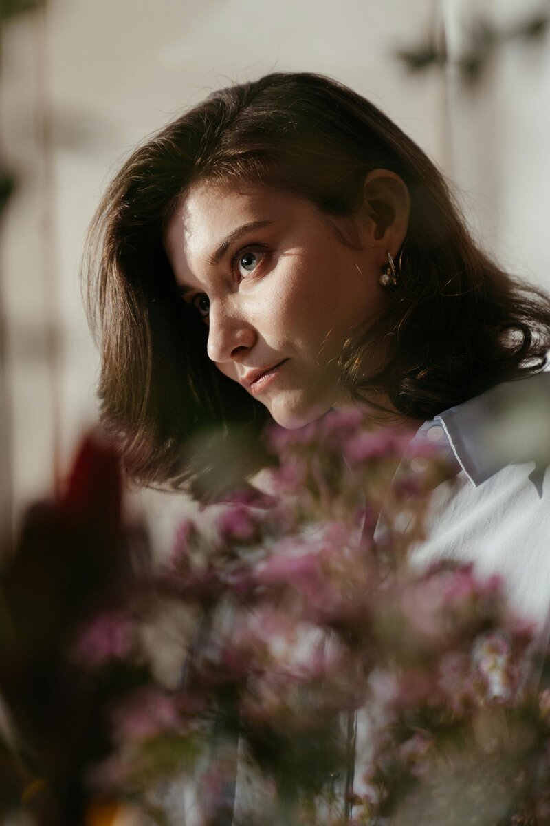 Photo is of imaginary client Nicole behind purple flowers