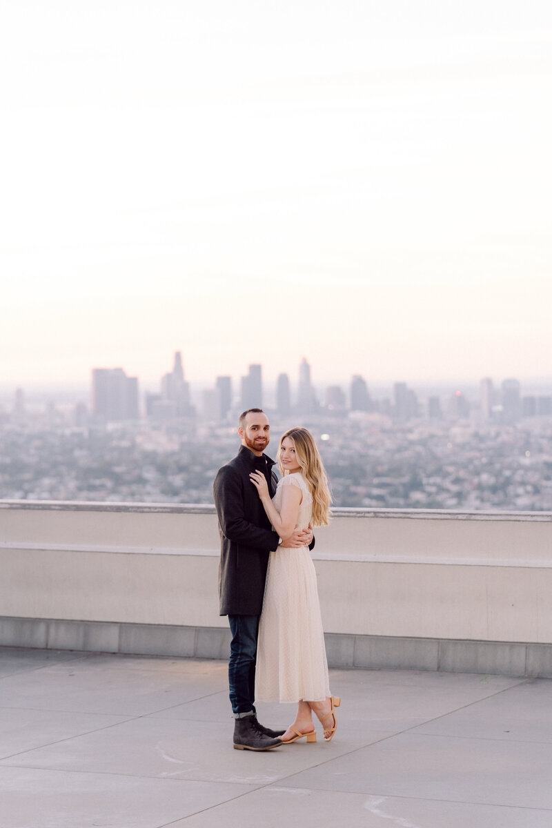 couple embracing at sunrise at the griffith observatory during engagment photos by los angeles wedding photographer magnolia west photography