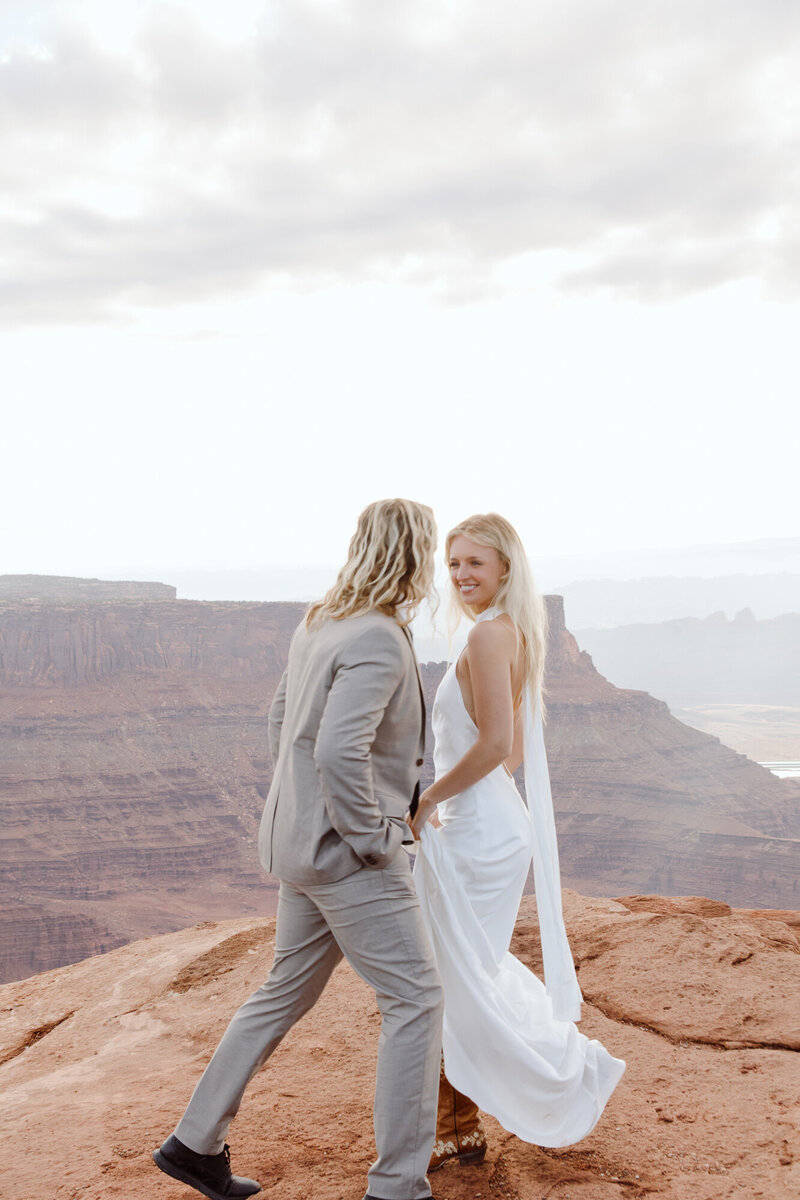 Couple laughing at each other while eloping at Dead Horse Point State Park in Utah