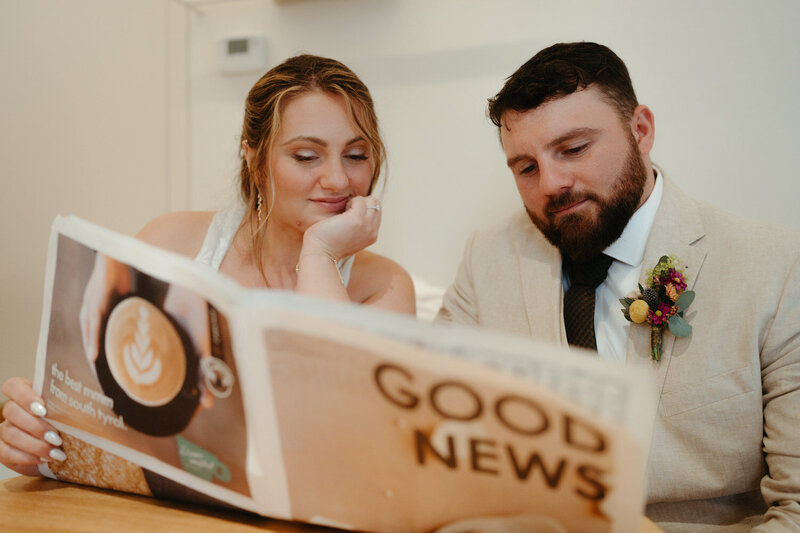 Bride and groom read a menu at a cafe during their dolomites elopement