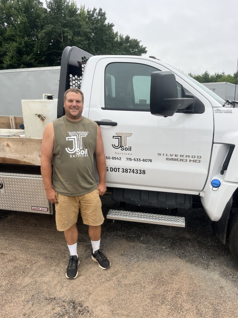 Tyler standing in front of the JT Soil Services truck