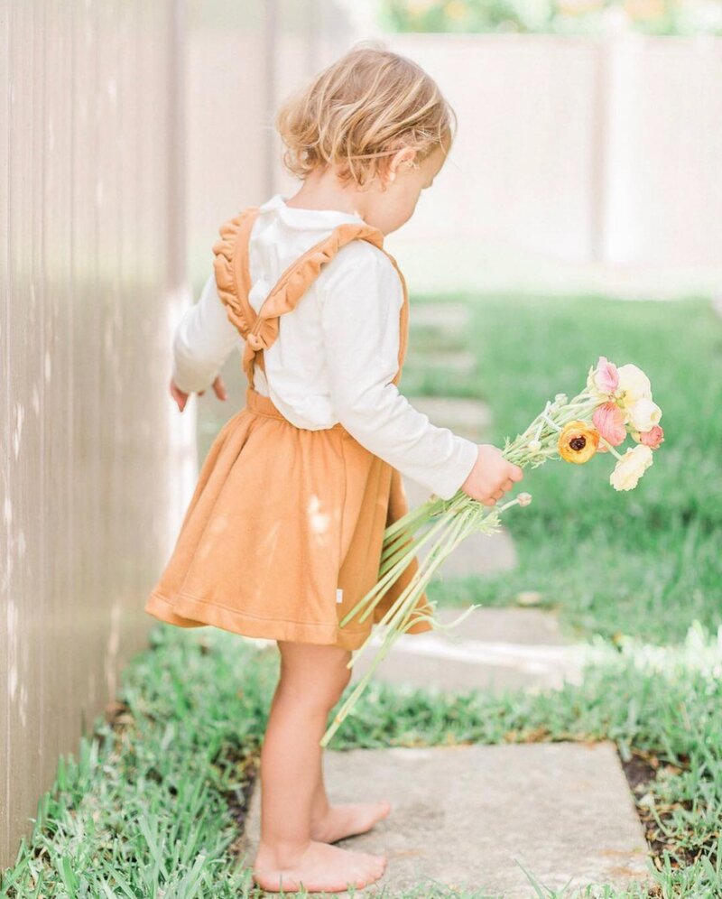 toddler picking flowers from learn to use your camera for moms course