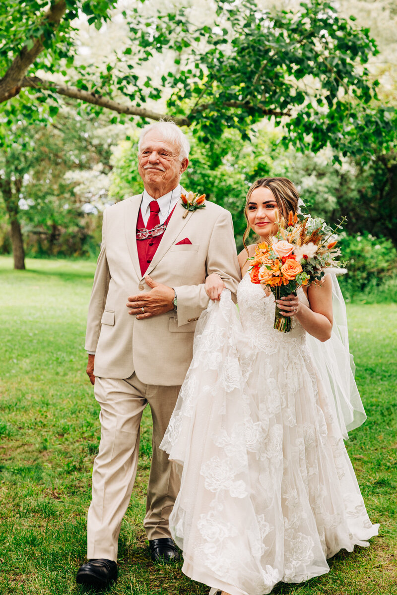 Father walking bride down aisle at Shades of Green Events venue in Huntley, MT