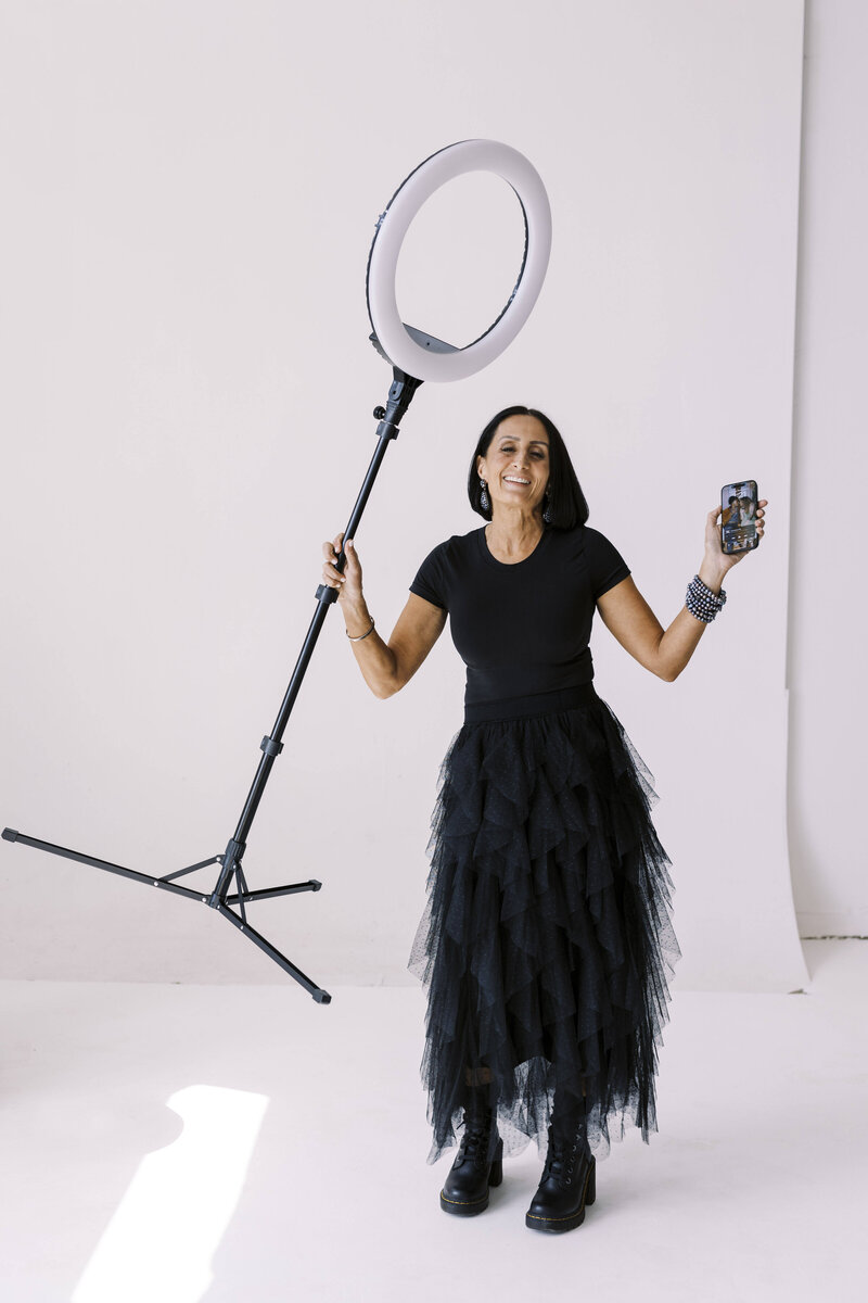 Tarah wearing a black tool dress holding stage light