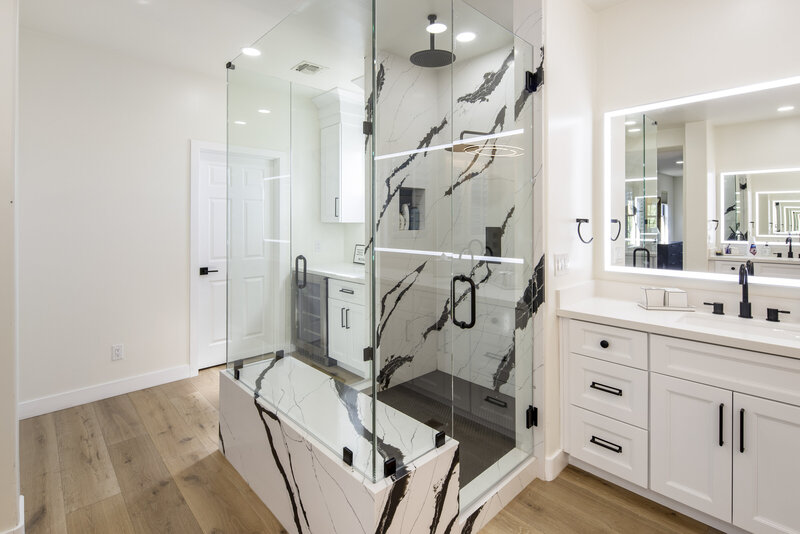 Master bath remodeled shower with marble backsplash, double glass doors and engineered hardwood floors.