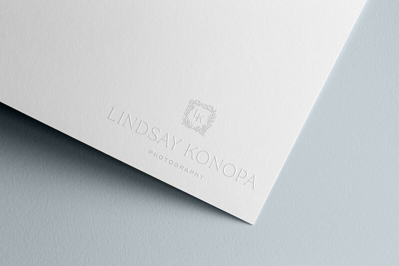 a mockup showing a photographer crest logo embossed on stationery