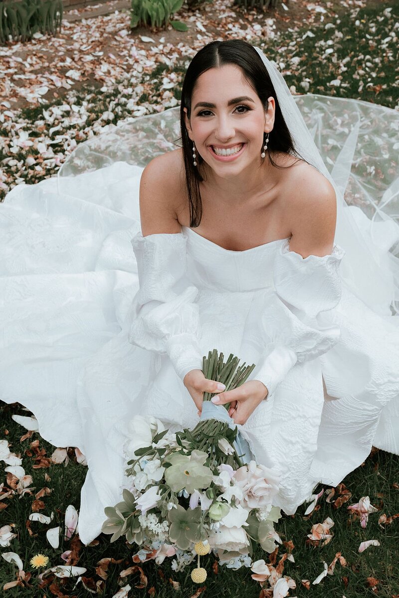 Bride and groom kissing in grassy field