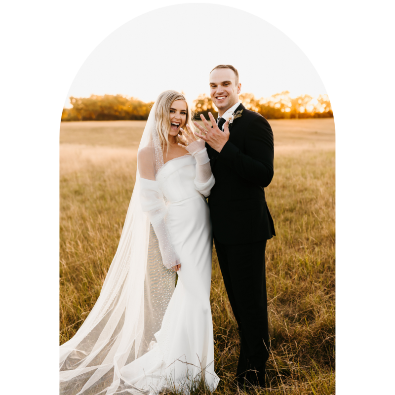 Bride and Groom smiling while showing their hands with wedding rings